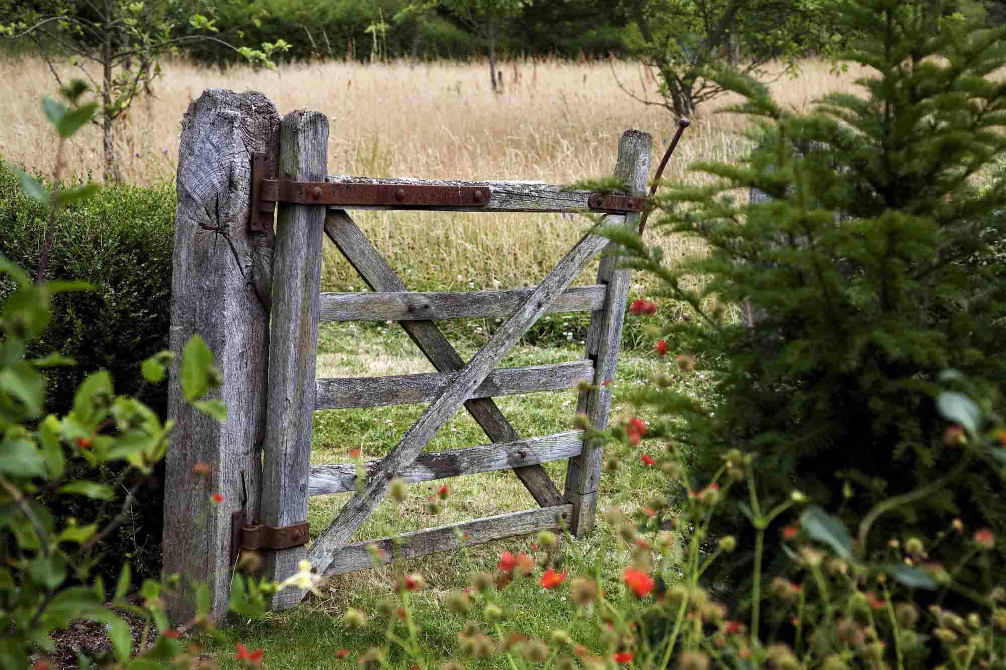 Old gate in garden leading to wildflower meadow at Leydens in Kent. Open for The NGS